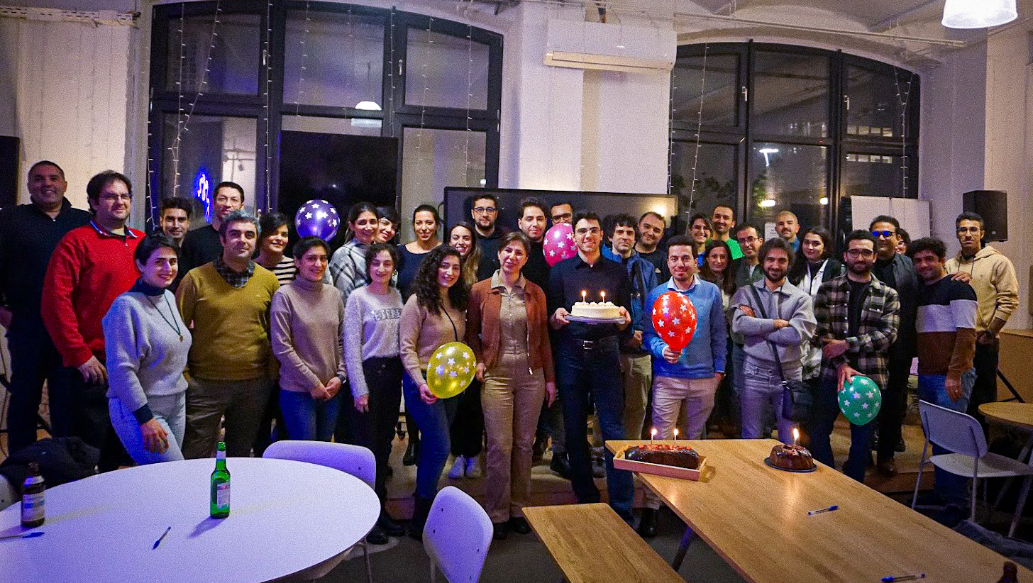 Experience Cafe community gathered around a birthday cake in Berlin