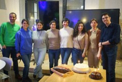 Members standing together with a cake at an Experience Cafe celebration