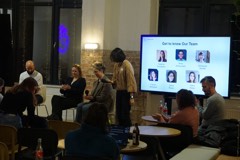 A host introducing the evening's speakers at Experience Cafe